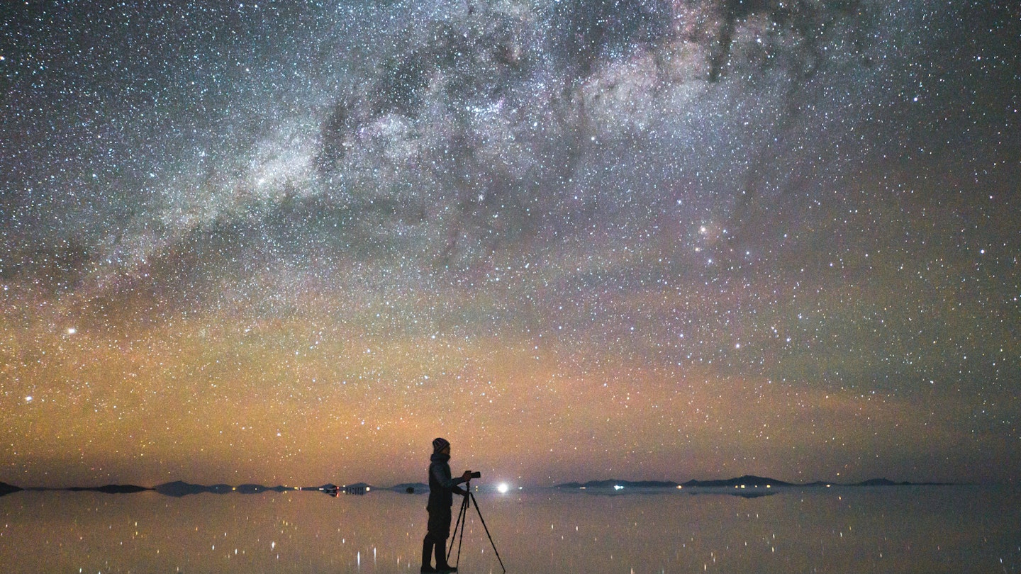1145977847
A person taking a photo of the Milky Way reflected in the salt flats in Uyuni, Bolivia