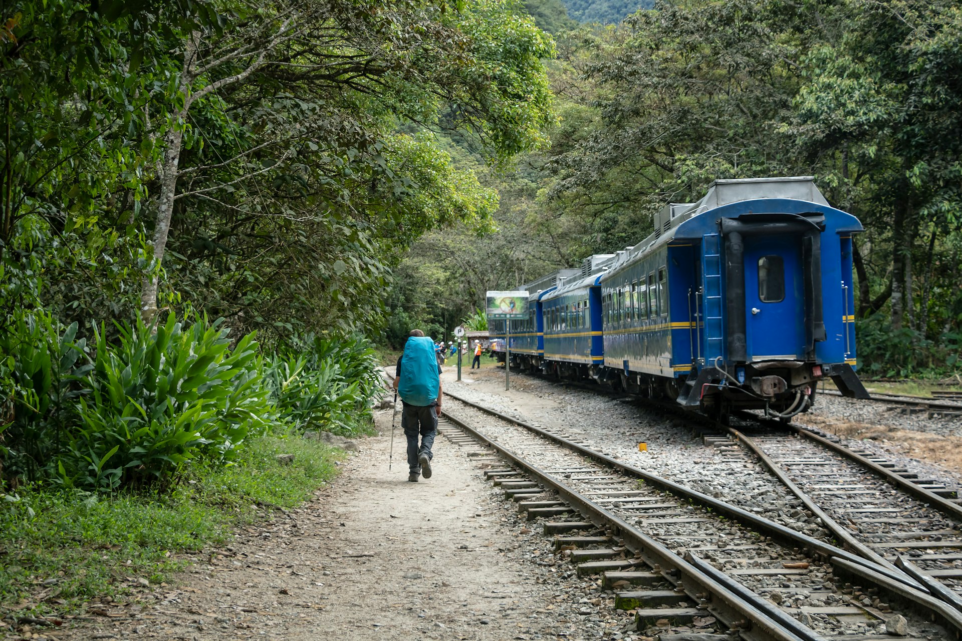 A backpacker walks along the tracks of the railroad leading to Machu Picchu from Hidroelectrica