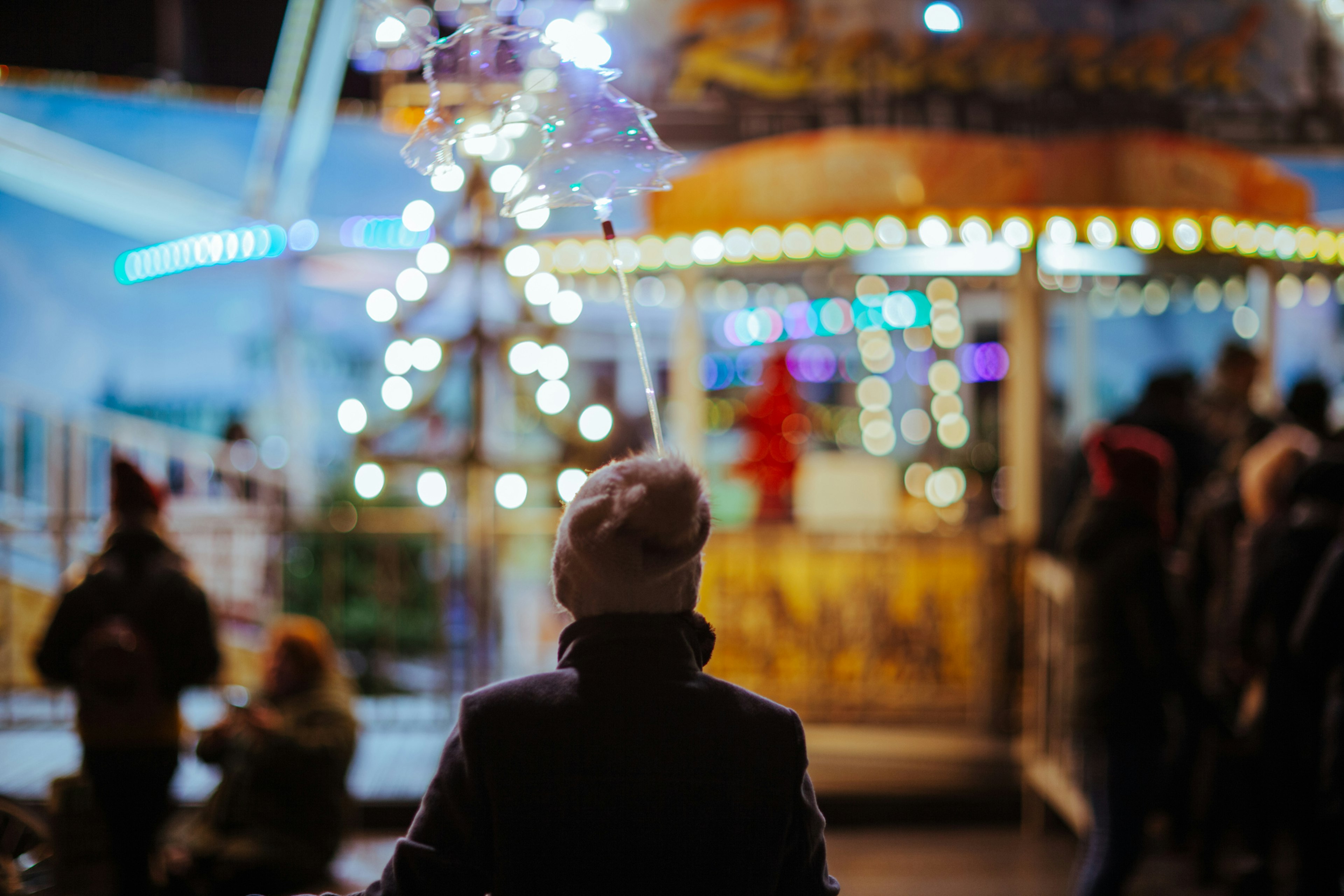 Christmas lights at the street market at night in Dresden, Germany with a young boy in a hat looking on