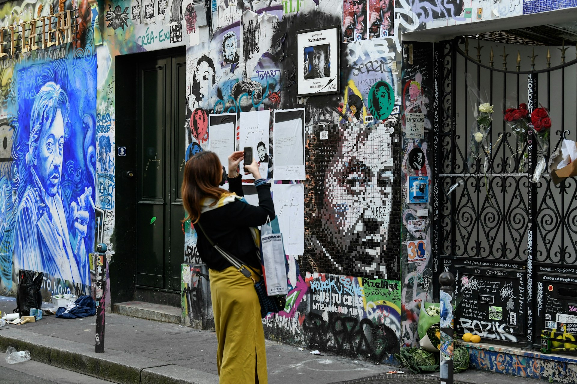 A woman takes a photo of the entry gate of the home of the late French musician, songwriter and singer Serge Gainsbourg in central Paris