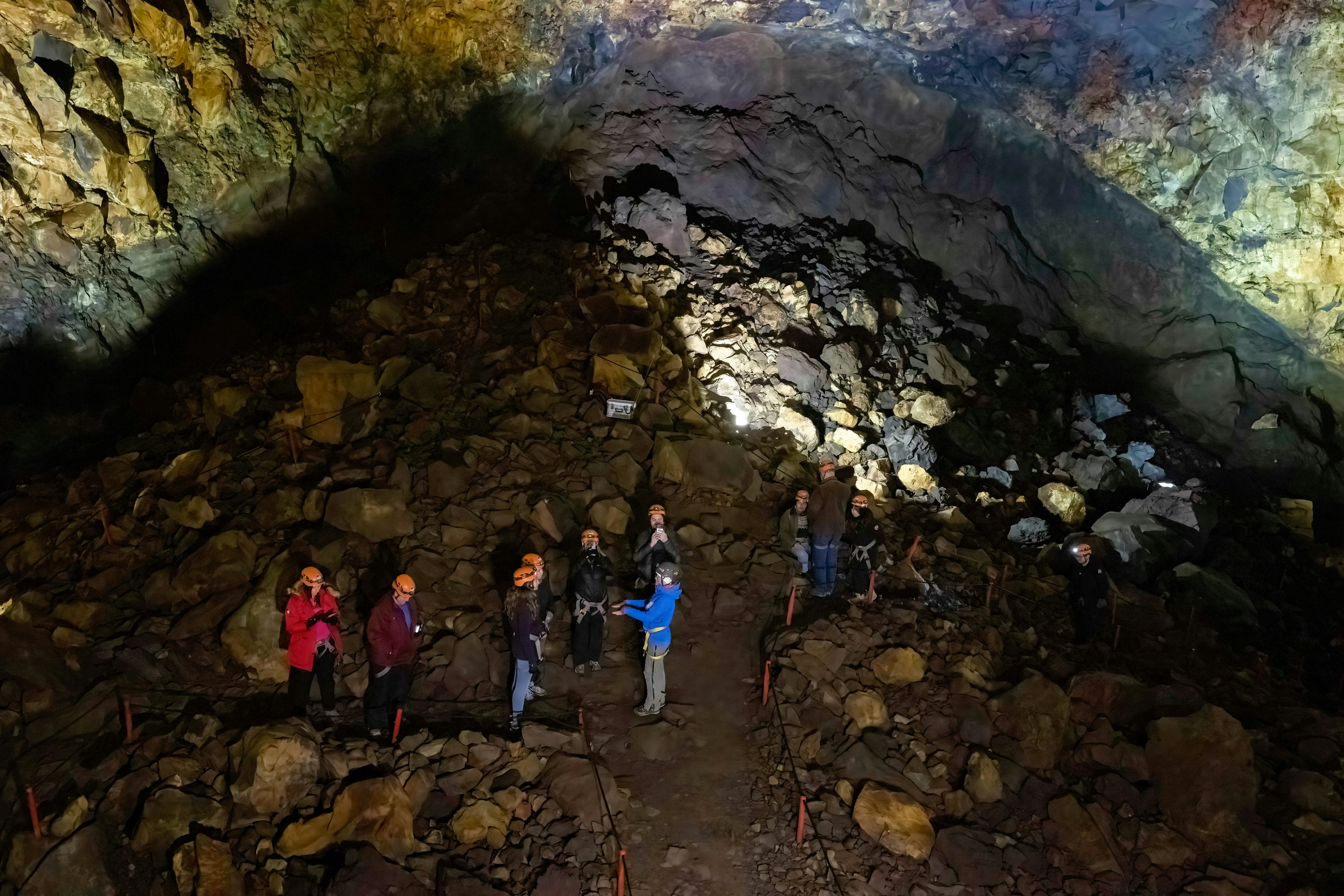 People walking through the cavern of Þíú첹íܰ volcano, Iceland