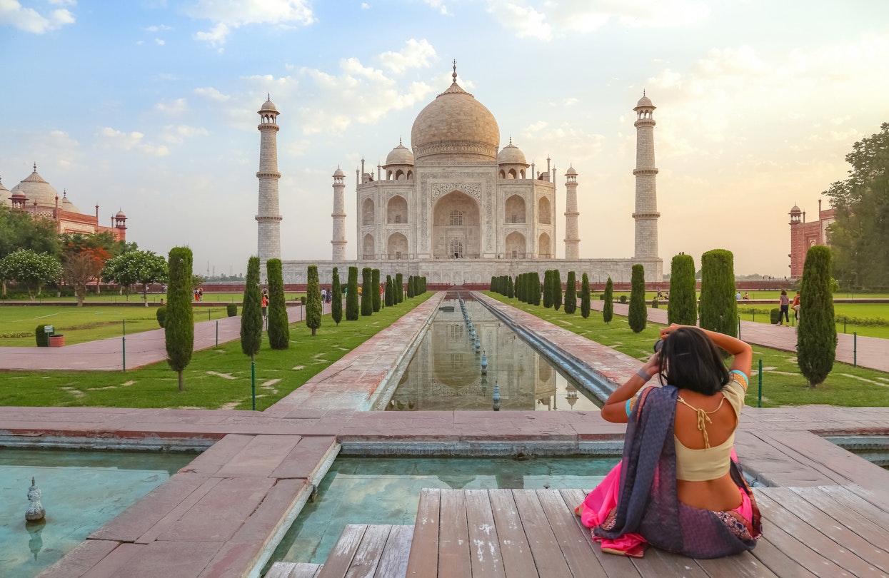 Agra, India, May 30,2019: Young female tourist in traditional Indian dress clicking photographs of the Taj Mahal at sunrise at Agra, India
1249326982
Taj Mahal Agra at sunrise with female tourist clicking photographs of the historic monument - stock photo
Agra, India, May 30,2019: Young female tourist in traditional Indian dress clicking photographs of the Taj Mahal at sunrise at Agra, India