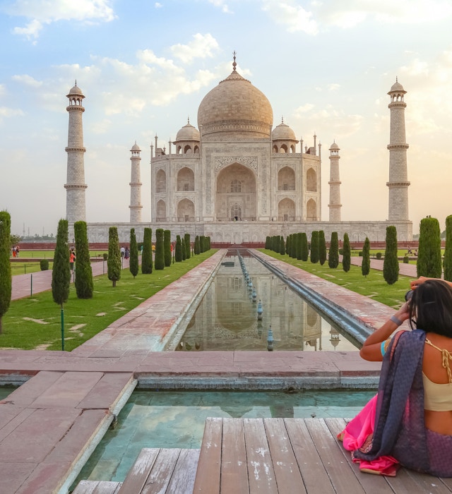 Agra, India, May 30,2019: Young female tourist in traditional Indian dress clicking photographs of the Taj Mahal at sunrise at Agra, India
1249326982
Taj Mahal Agra at sunrise with female tourist clicking photographs of the historic monument - stock photo
Agra, India, May 30,2019: Young female tourist in traditional Indian dress clicking photographs of the Taj Mahal at sunrise at Agra, India