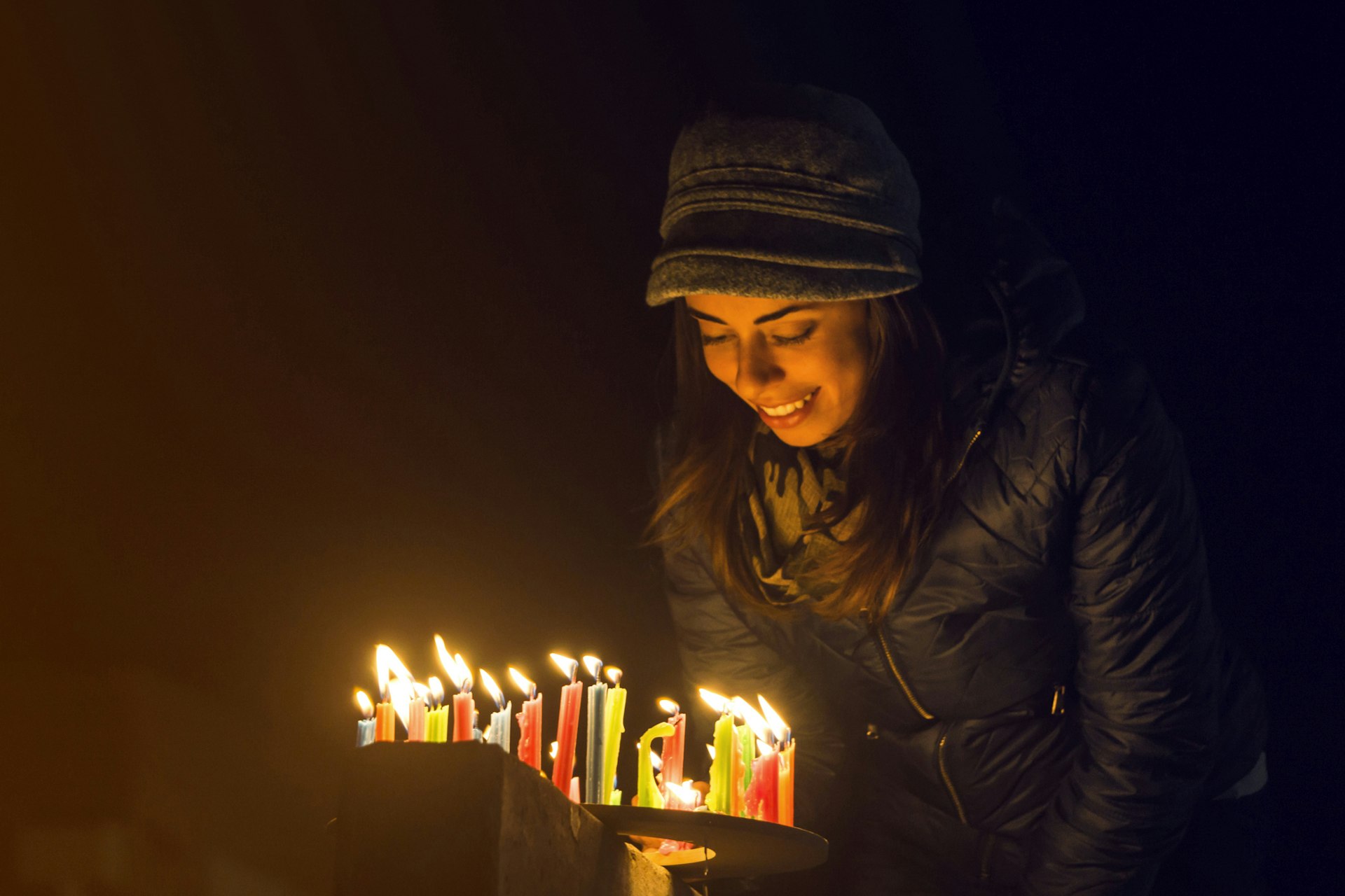 Happy Colombian woman lighting candles outdoors during the Noche de Velitas celebration that takes places on the 7th of December and marks the beginning of Christmas time