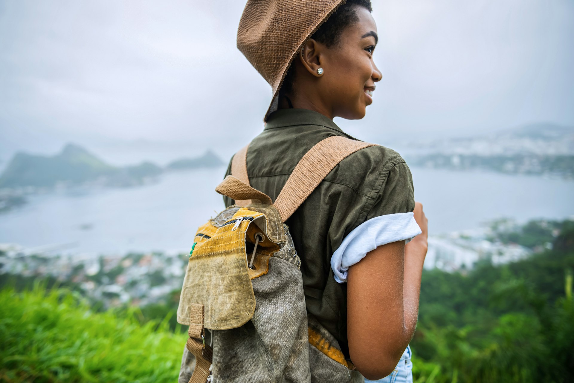 A woman with a backpack looks out over a view of Rio de Janeiro