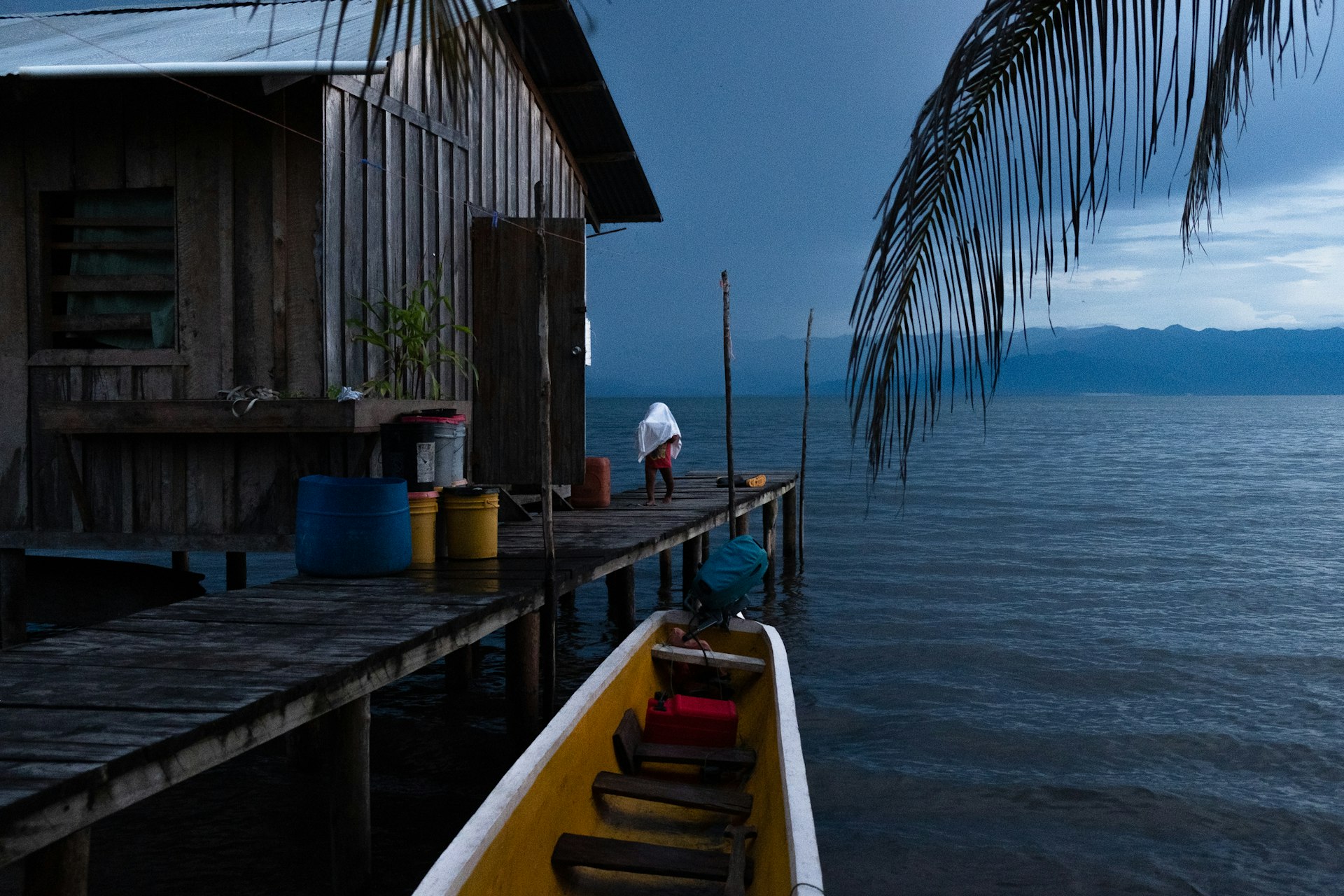 A kid from Cayo de Agua Island gets the laundry from the outside, Bocas del Toro, Panama