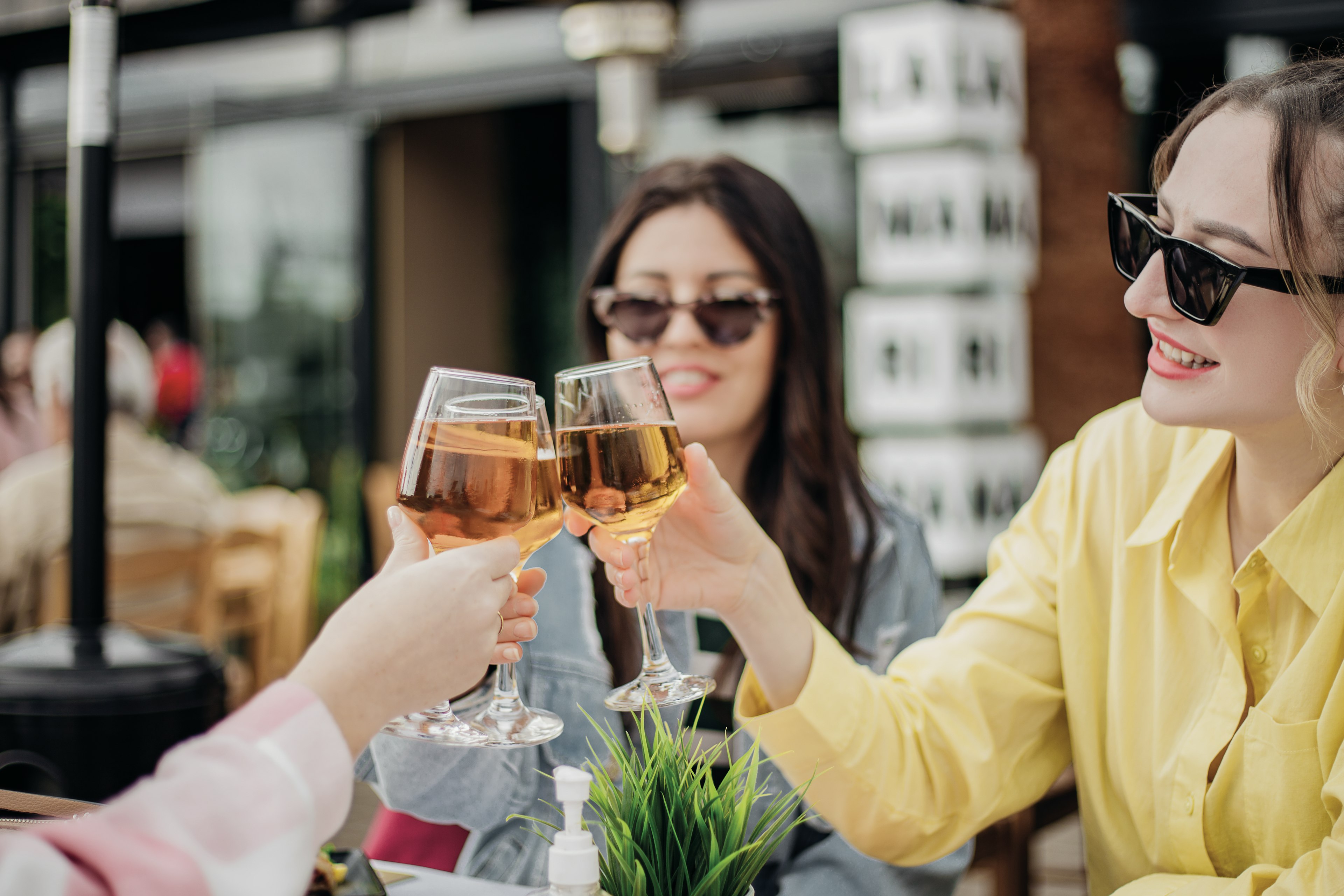 Women toast with glasses of white wine at a restaurant in Athens, Greece