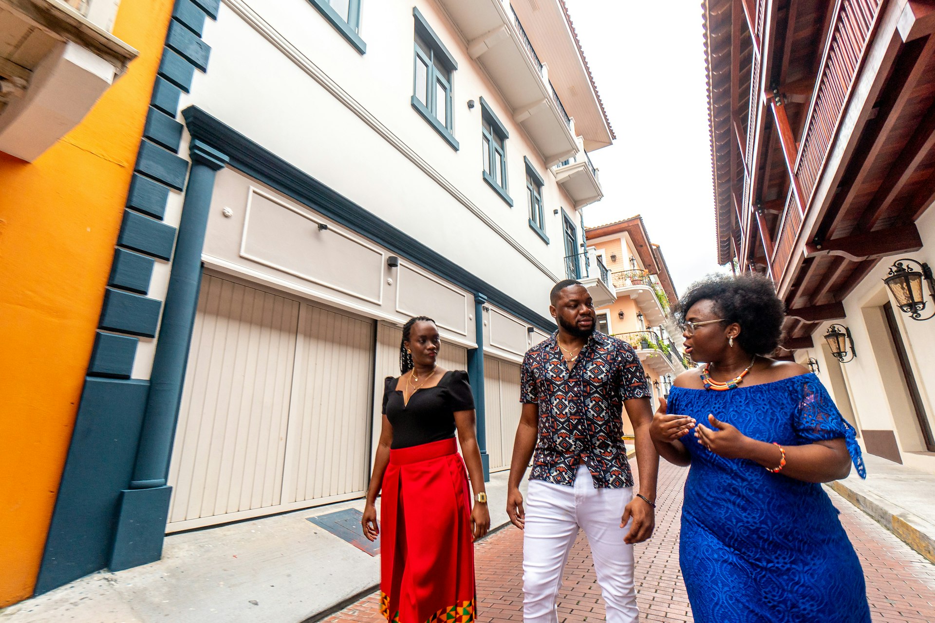 Wide Angle Image of Fashionable Afro-Descendant Black Woman Giving a Walking Tour to a Well-Dressed Couple in the Streets of the Huerta Sandoval Neighborhood of Panama City,