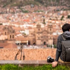 Asian man tourist and photograpaher sitting on viewpoint looking at cusco city. Cusco (Cuzco) is a city in southeastern Peru, near the Urubamba Valley of the Andes mountain range
1443012578