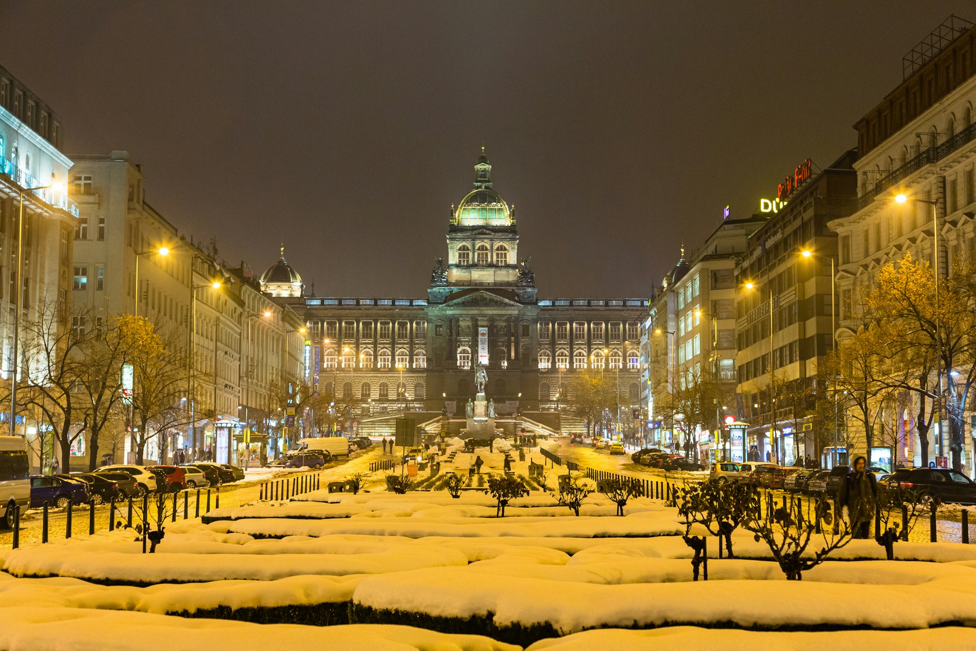 Wenceslas Square in Prague covered in snow looking up at the spires of the national museum