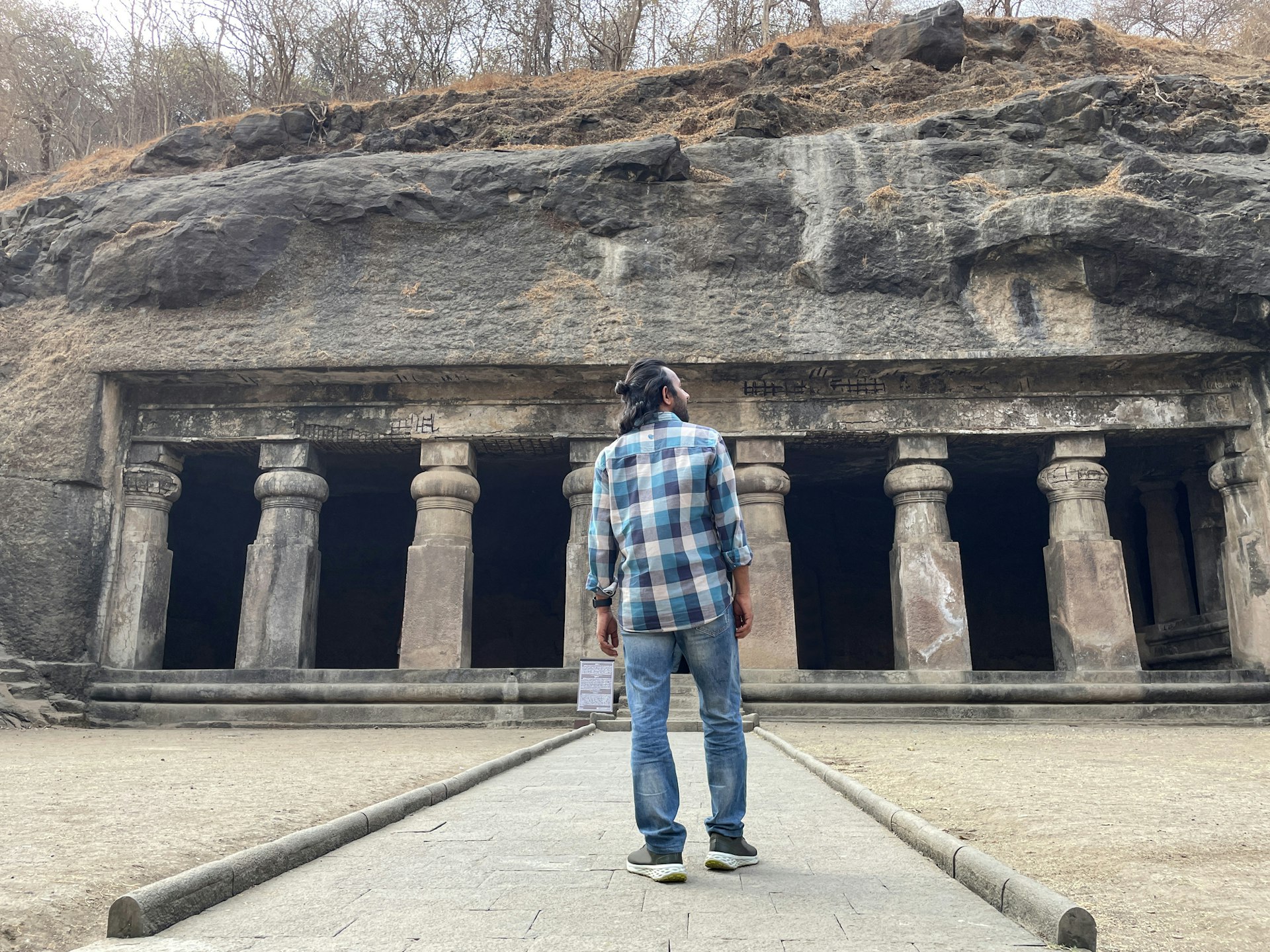 A man stands in front of the entrance to the Elephanta Caves, Mumbai
