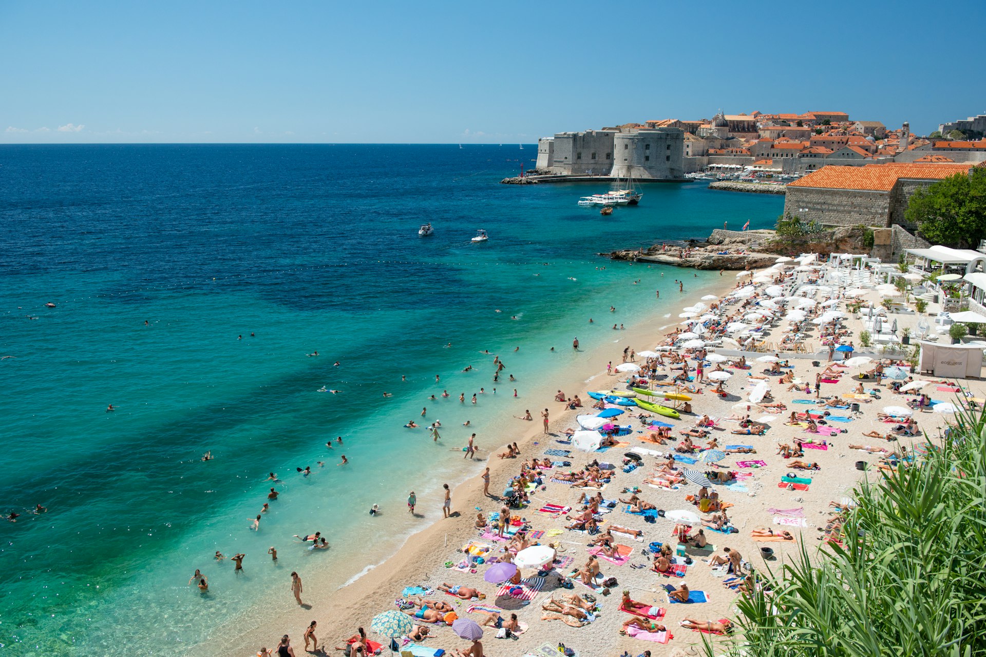 View of a packed beach with the Old Town Harbor in the background, Dubrovnik, Croatia