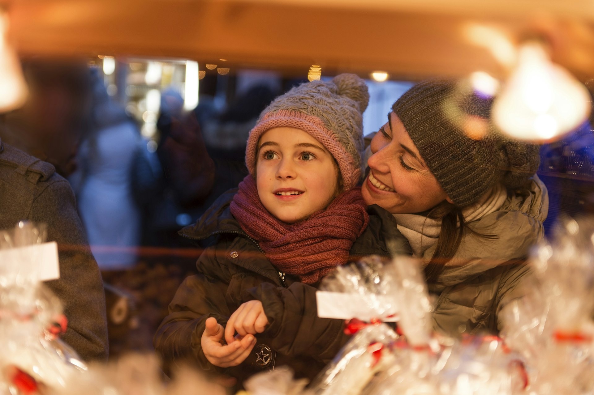 A happy child and mother choose some sweets at a Christmas market in Nice, France 