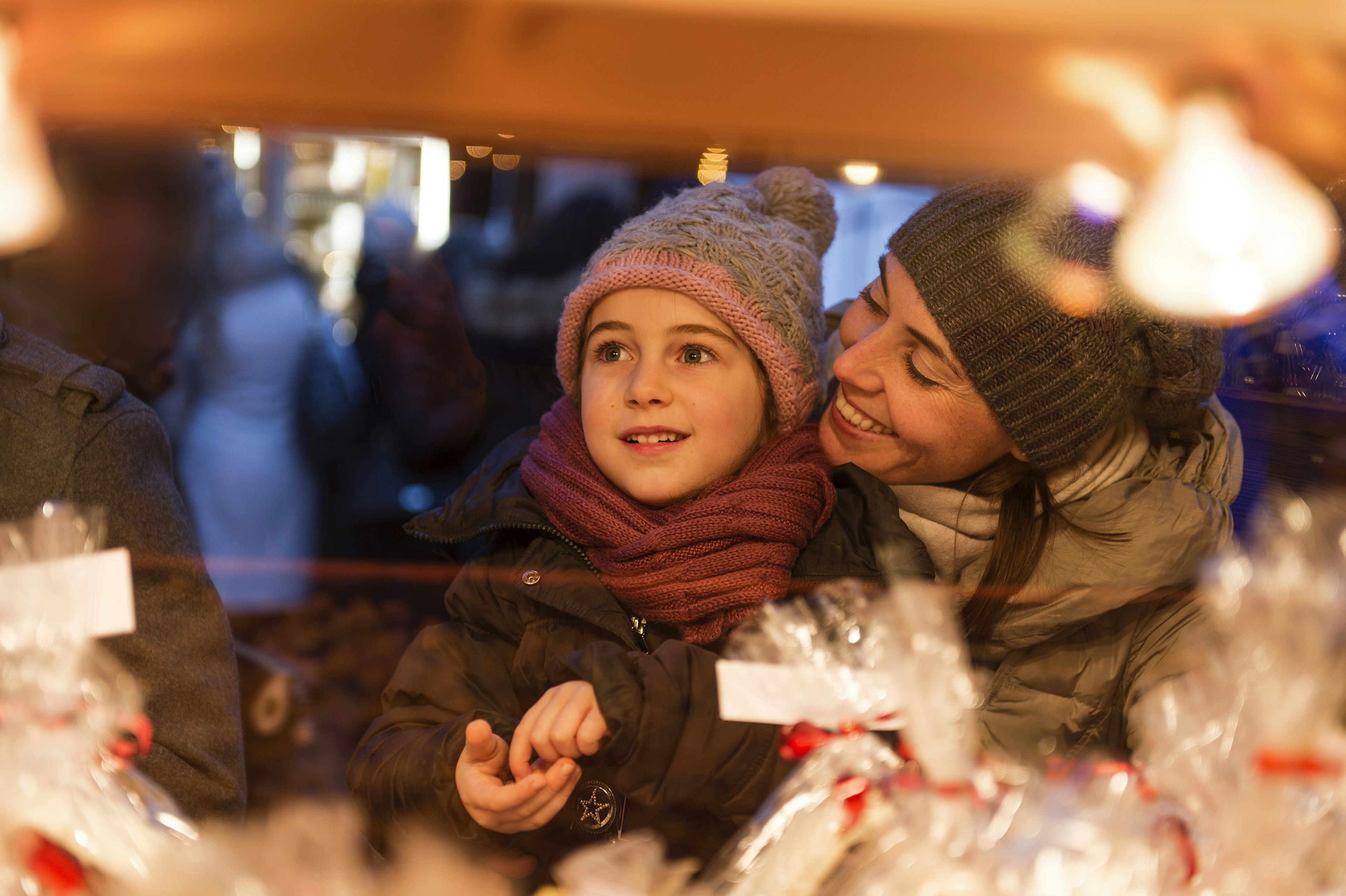 A happy child and mother choose some sweets at a Christmas market in Nice, France