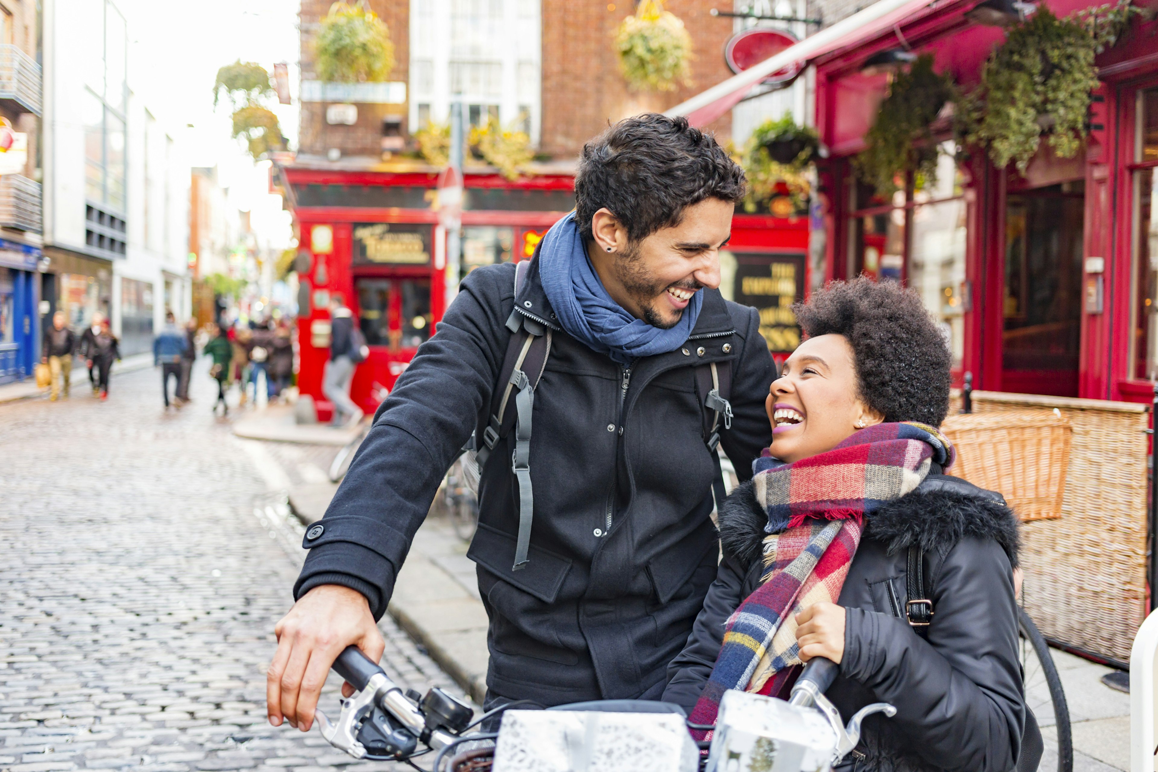 A young, mixed-race couple laughing together in Temple Bar, Dublin