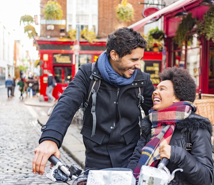 A young, mixed-race couple laughing together in Temple Bar, Dublin
