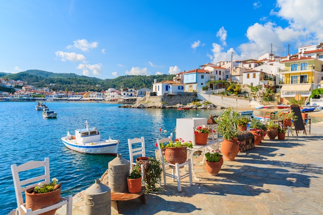 Flower pots on and view of fishing boats anchoring in Kokkari bay, Samos island, Greece - stock photo
Samos is a Greek island in the eastern Aegean Sea, south of Chios, north of Patmos.
© pkazmierczak / Getty