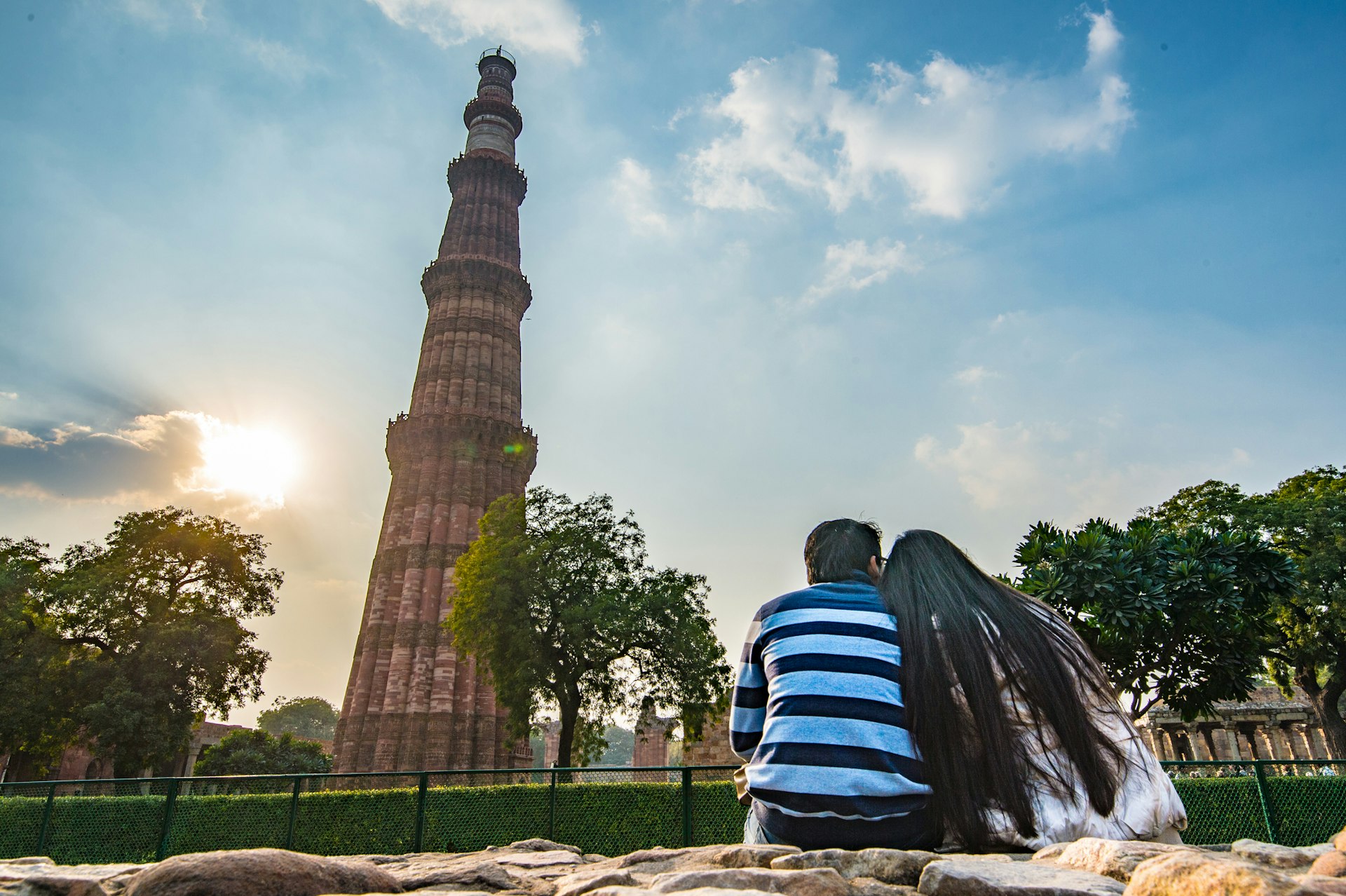 A couple is seen sitting and taking in the sights of the Qutub Minar as the sun sets. The Qutub complex is located in New Delhi, India.