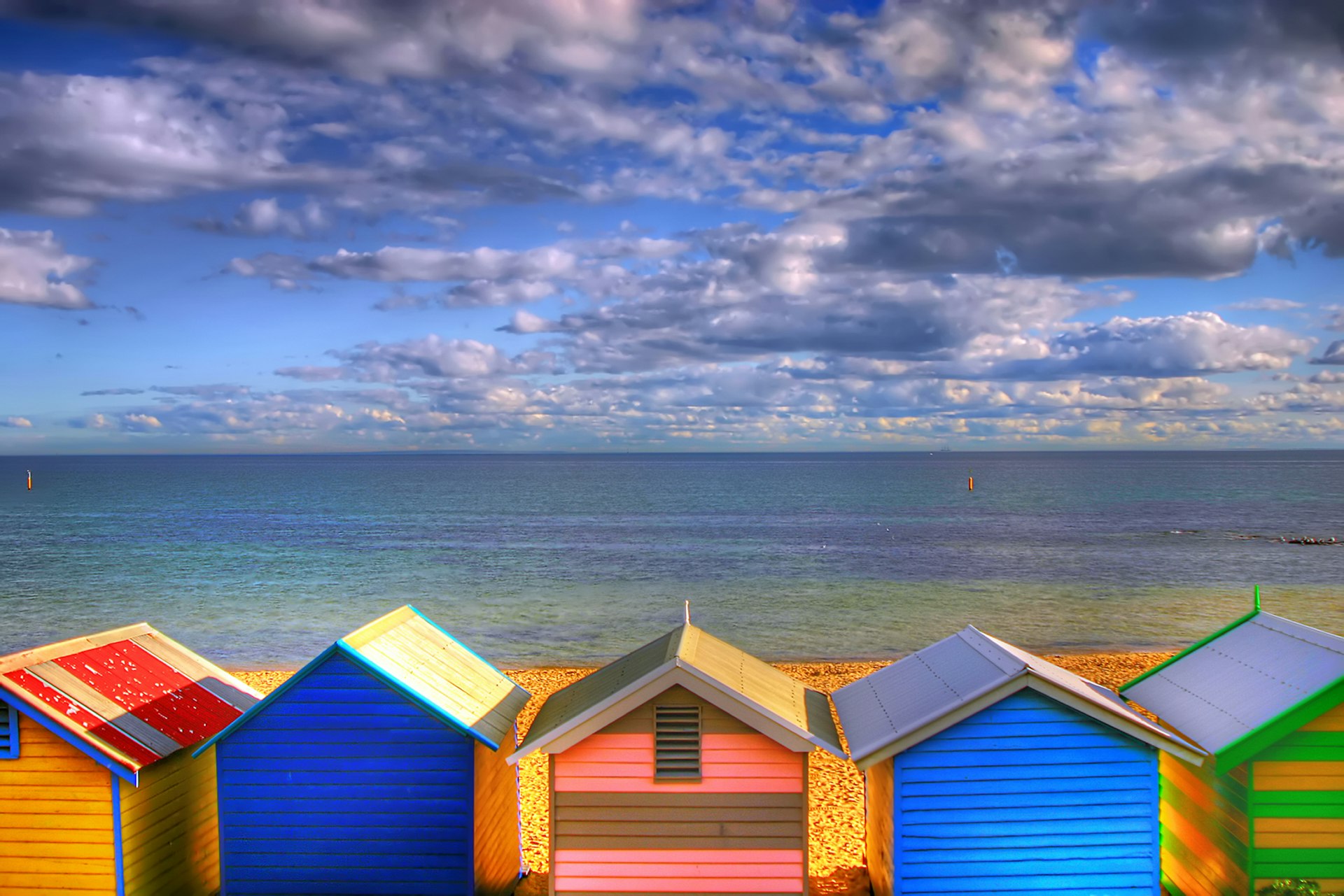 A row of colorful beach huts faces the sea