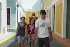 Three friends walking along a cobbled street in San Juan, Puerto Rico