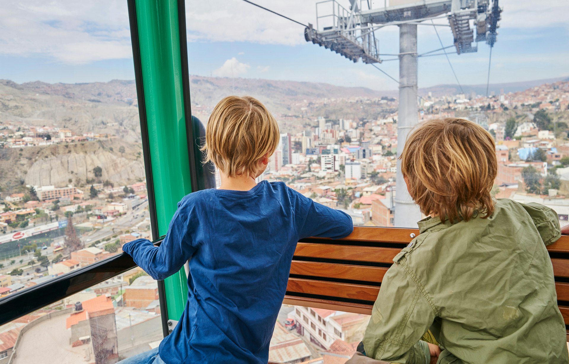 Two young boys looking down on La Paz from a cable car, Bolivia