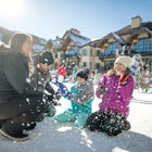 A family playing in the snow at a resort in Vail, Colorado