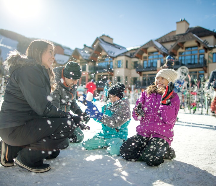 A family playing in the snow at a resort in Vail, Colorado