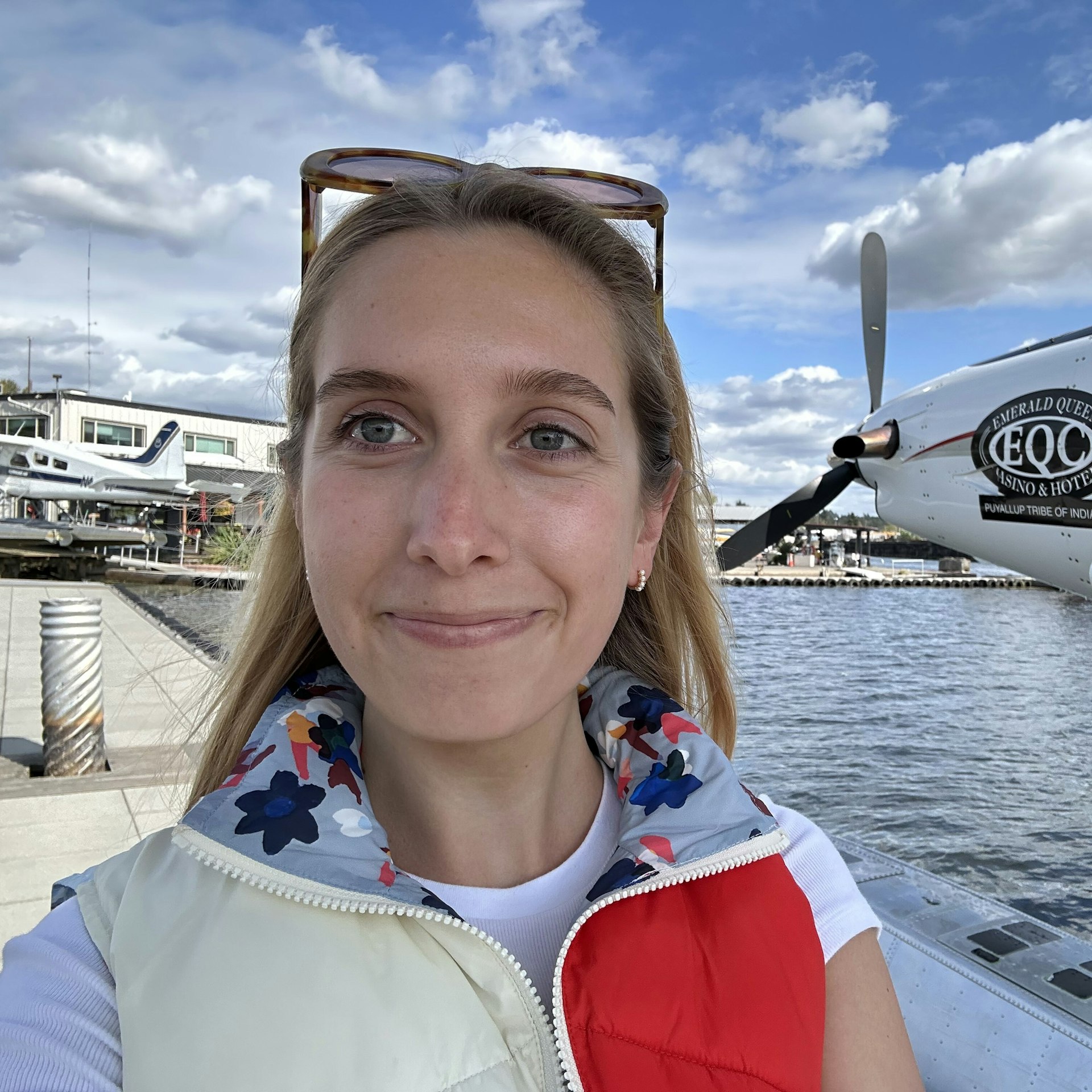 Ann Douglas Lott standing on a harbourside walkway, with the rear propeller of a seaplane behind