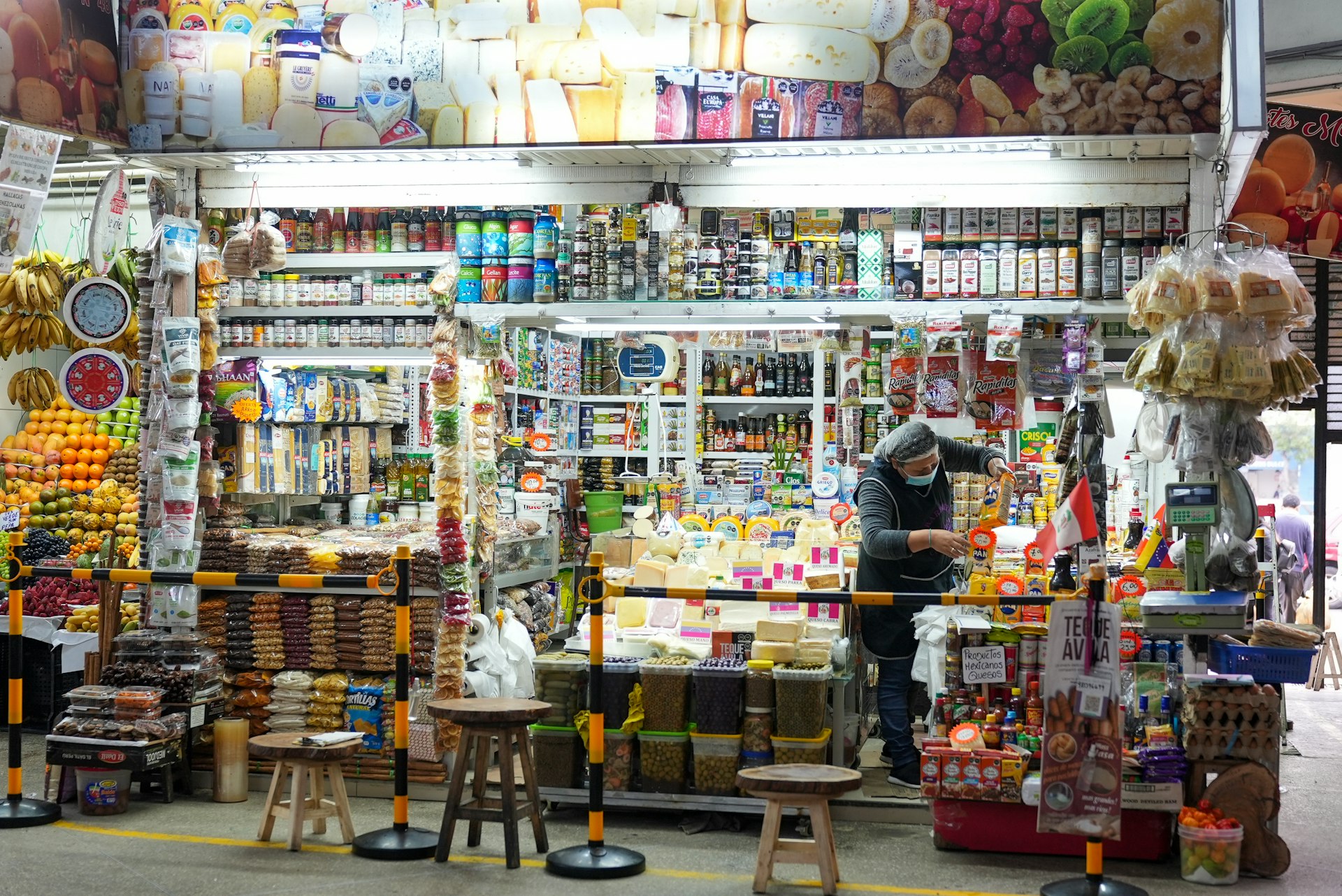 A woman checking her stock in a shop in Mercado de Surquillo, Lima