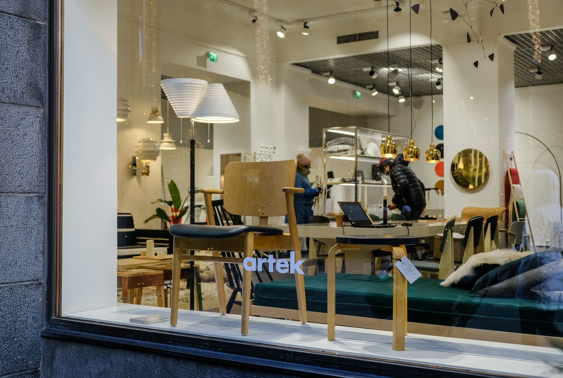 Customers seen through the Artek store window browsing - Helsinki, Finland