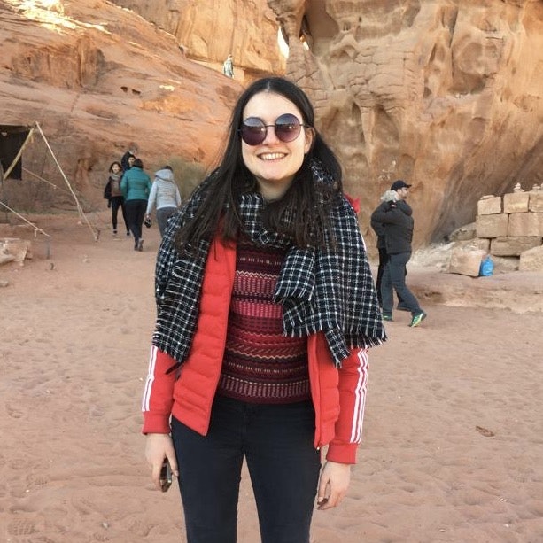 Zara Sekhavati standing in front of high, pinkish-brown rock formations in Jordan