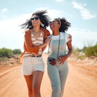 Two women walking along a path in a park in Kenya while laughing together