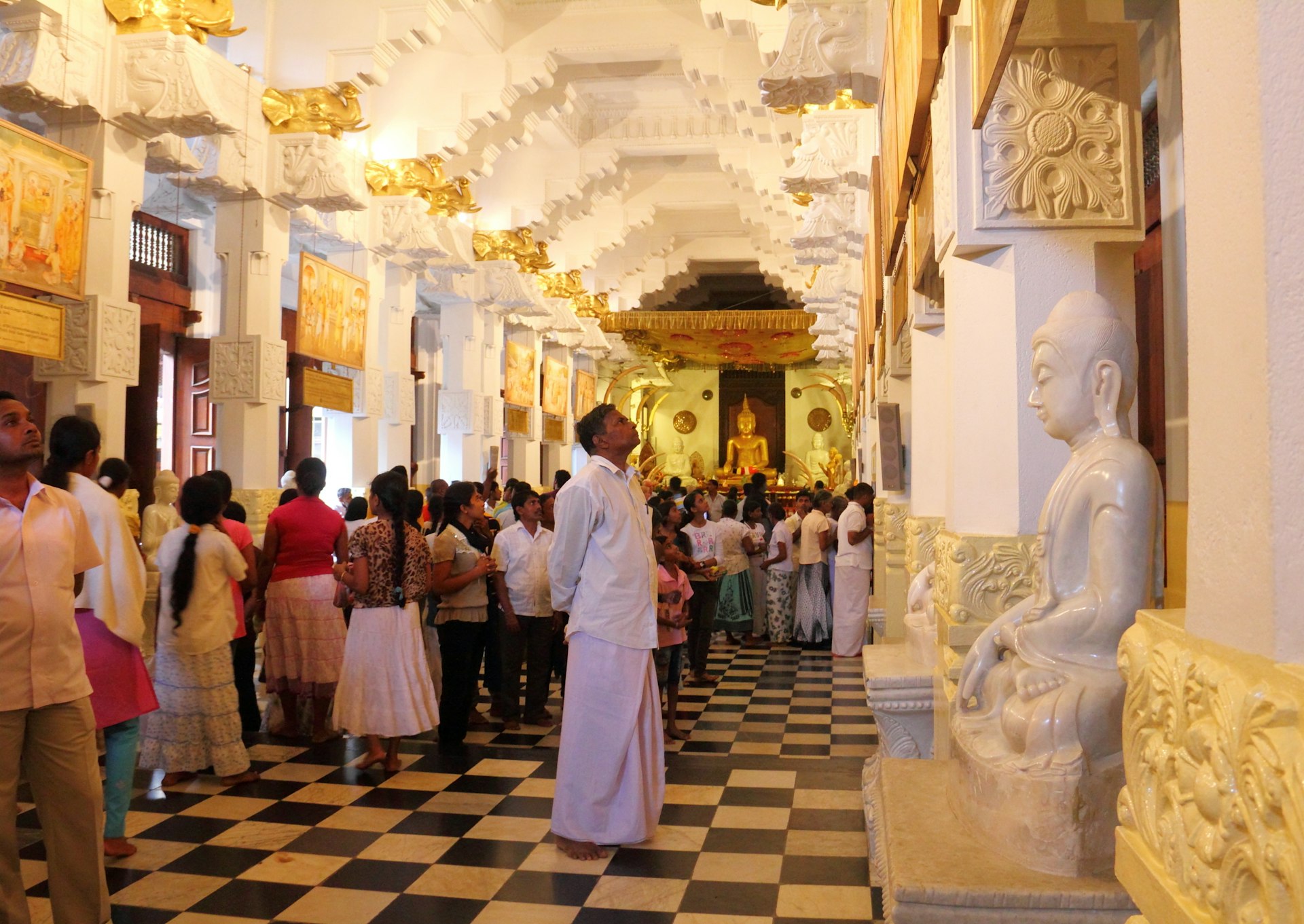 Crowds of people pay respect to the Buddhist relic in Temple of the Buddha Tooth, Kandy, Sri Lanka.
