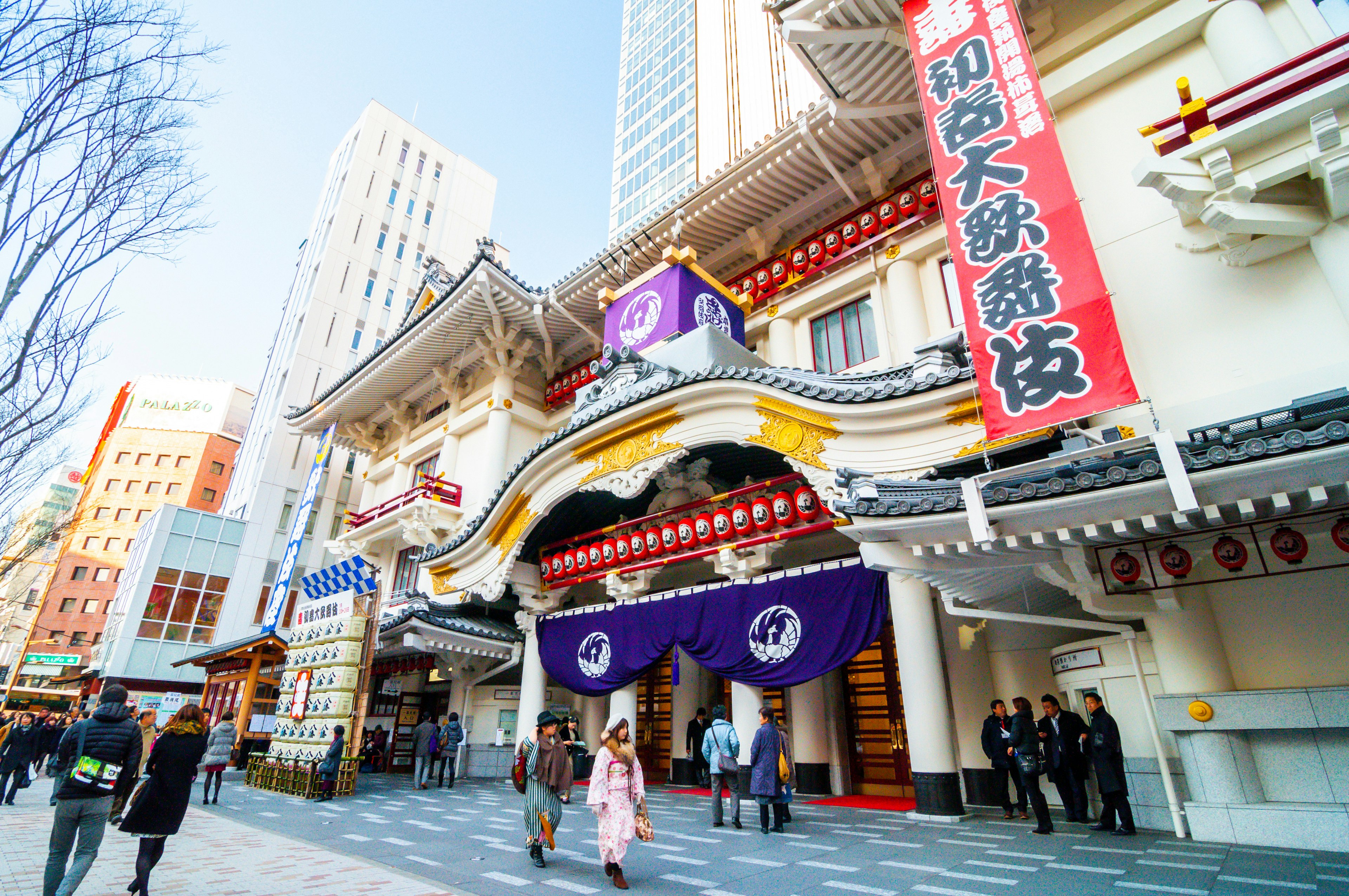 People walk in front of the Ginza Theater on a sunny day