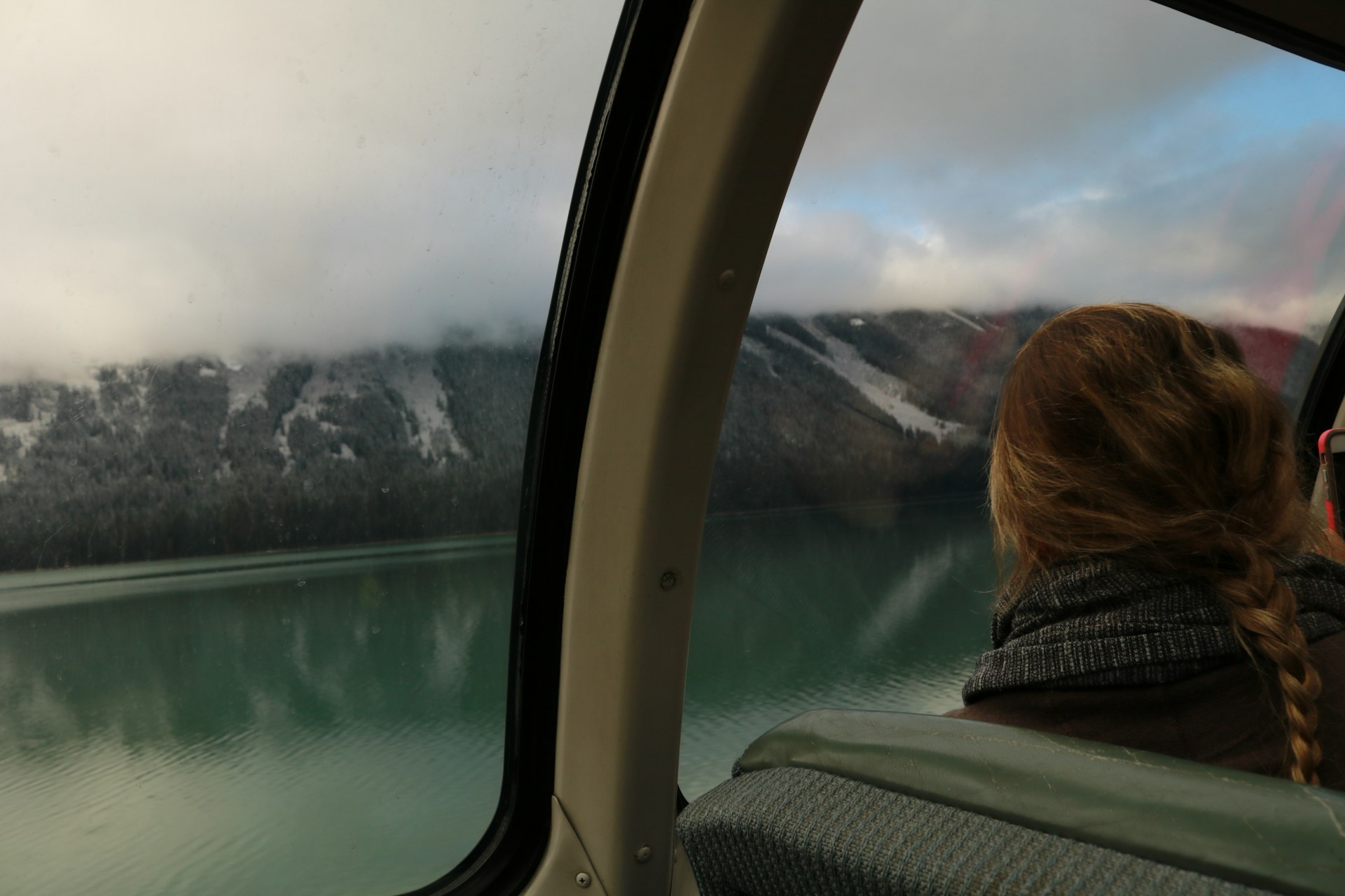 A woman looks out the window of a train car at the scenery in Jasper National Park