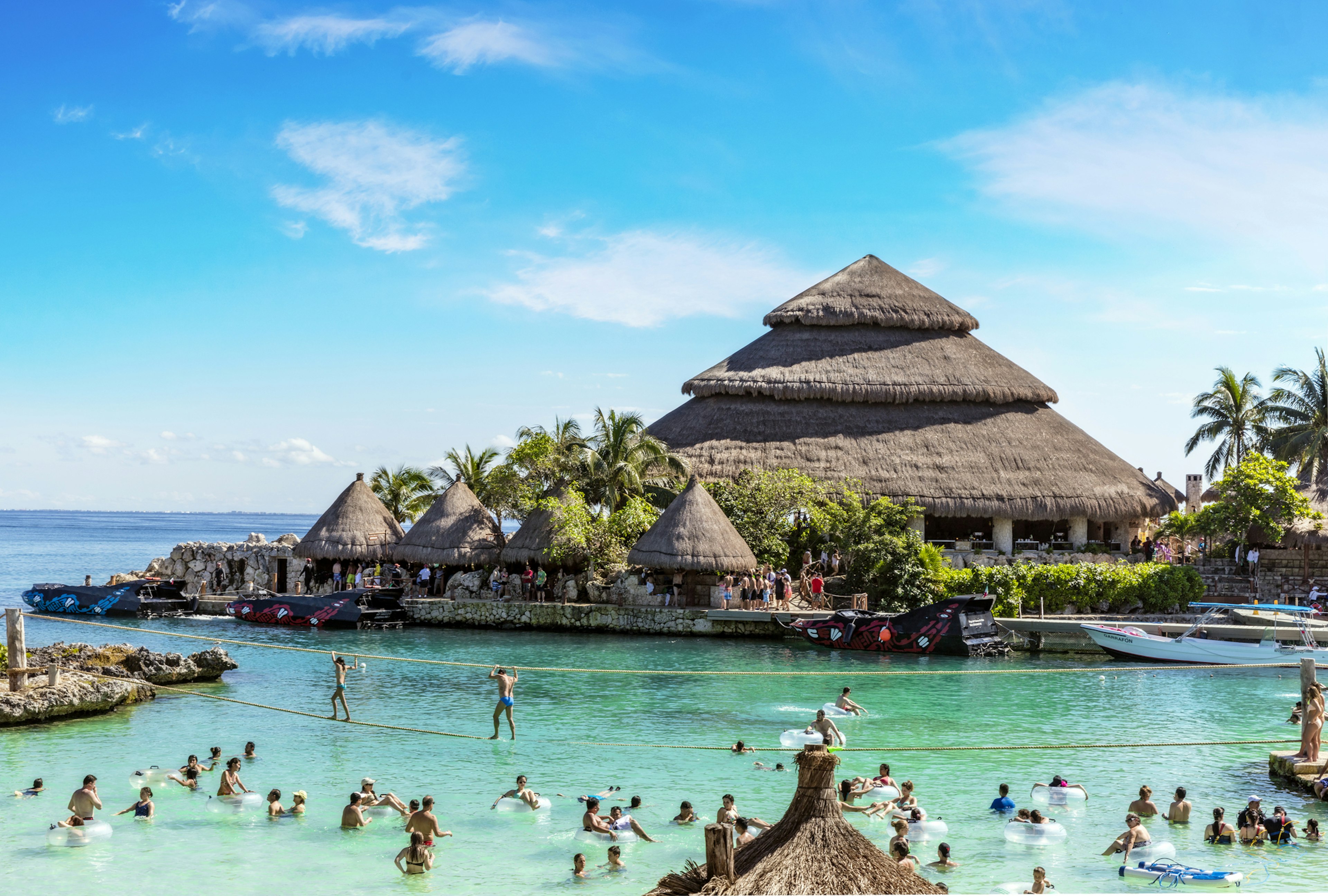 People swim, paddle and play in a vast pool at a water park