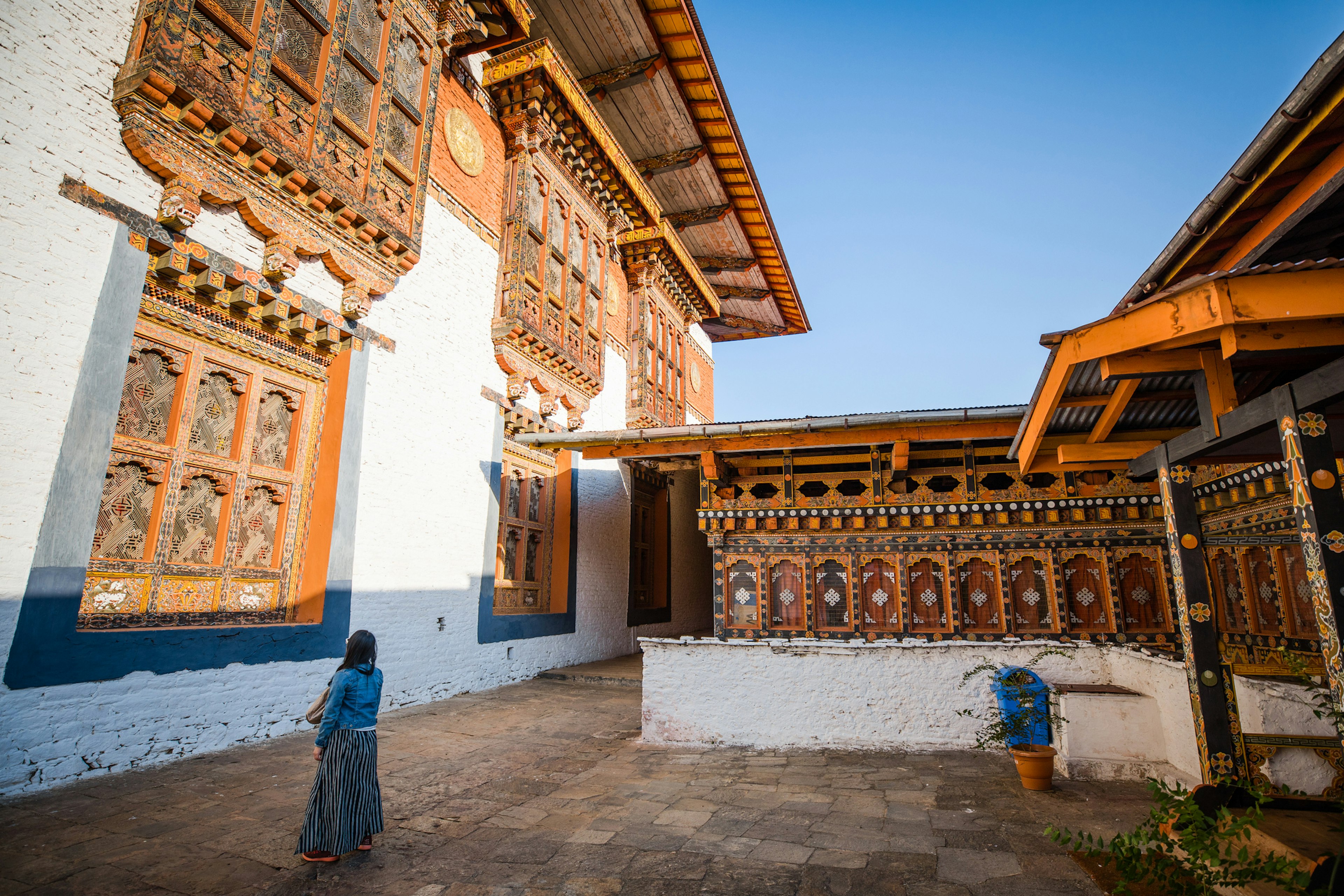 A female tourist looks at the intricate carvings around the windows of an ancient building