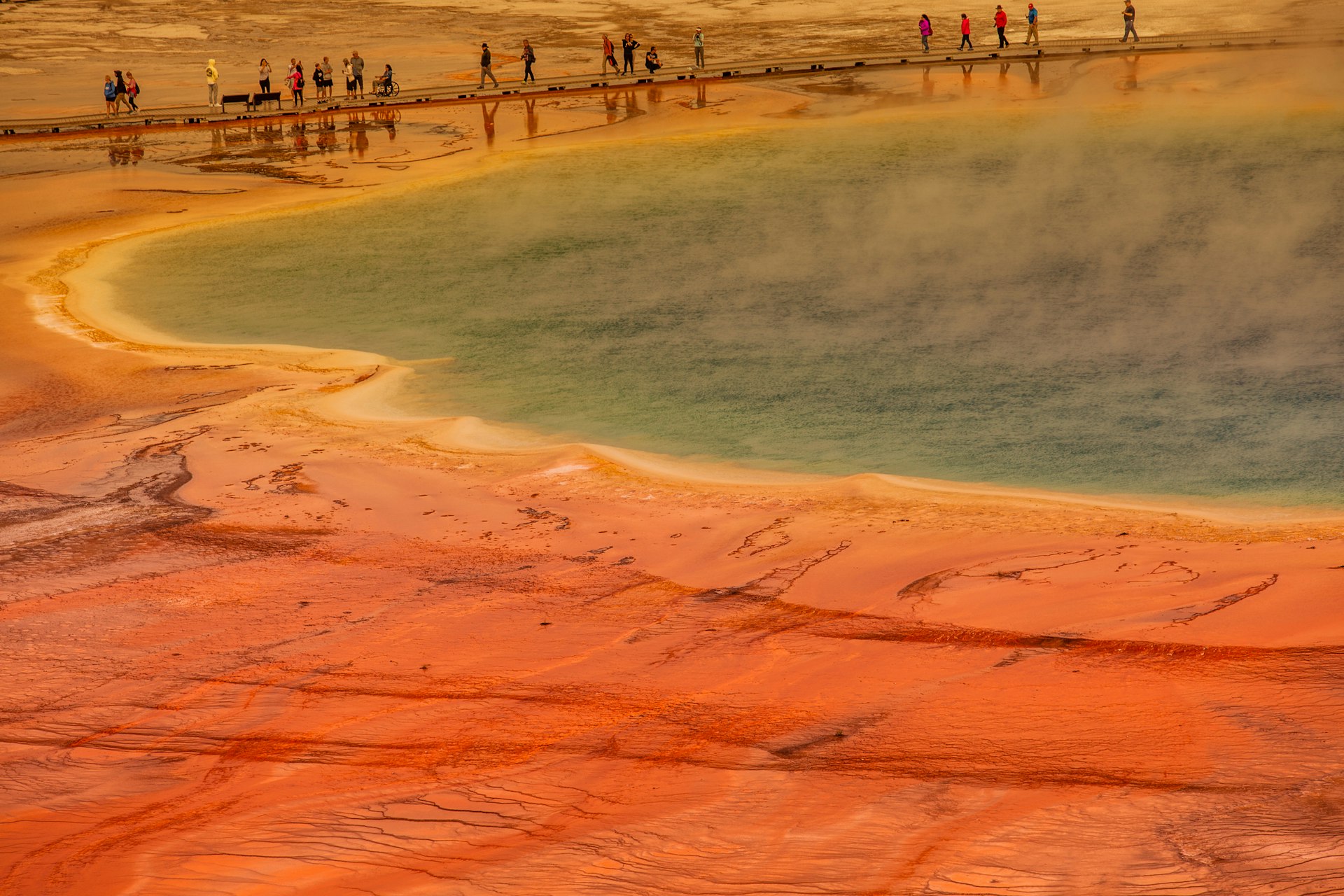 Visitors of the Grand Prismatic Spring walking on the pathway above the hot volcano landscape in Yellowstone National Park, WYO, USA.