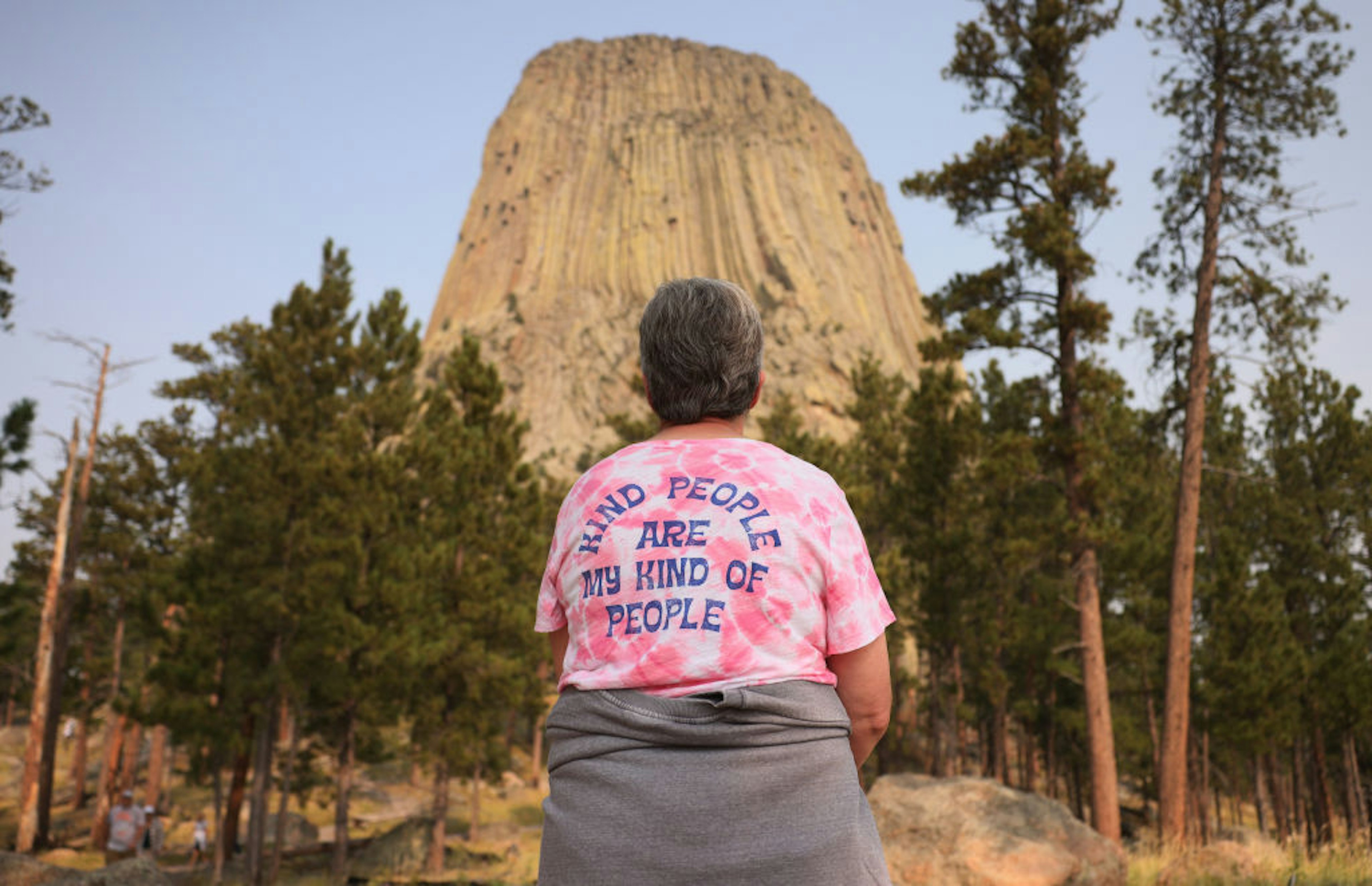 A woman pauses to take in the view of Devil's Tower as she hikes along the trail that surrounds it.