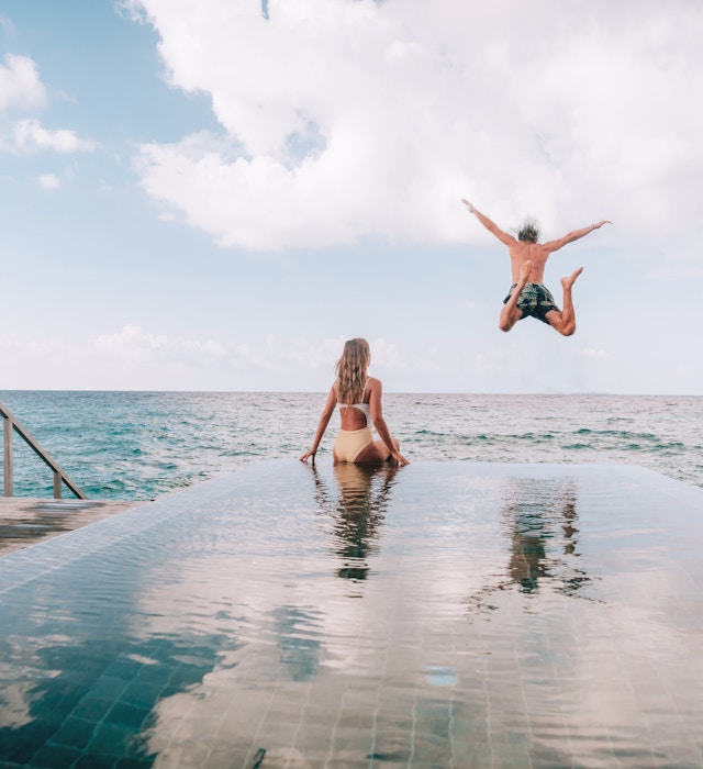 Couple enjoying luxury vacations - stock photo
Couple enjoying tropical vacations from the edge of an infinity pool in private over water villa. People travel luxury holidays