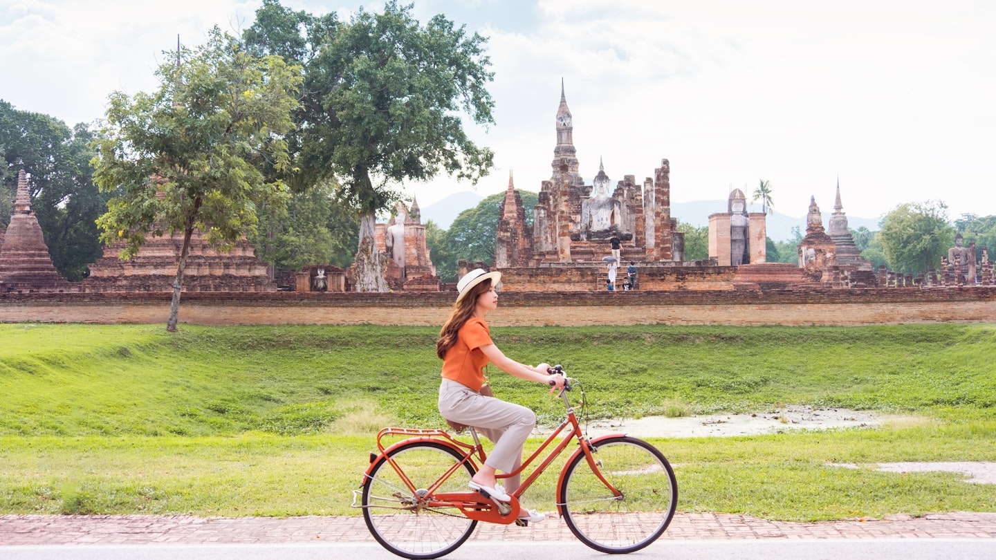 1284234549
an asian female tourist sightseeing Sukhothai historical park on a bicycle.