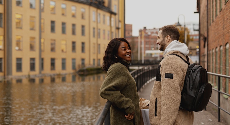 A woman and man laughing together next to a canal in Sweden