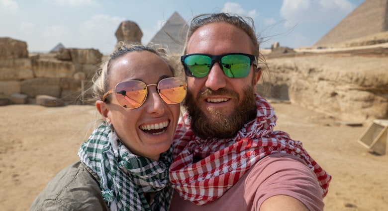 Front view of a couple tourists enjoying a tour to the Pyramids of Giza in Egypt.
1307363682