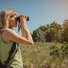 Young woman bird watching with binoculars at Indiana Dunes State Park.
1325470474