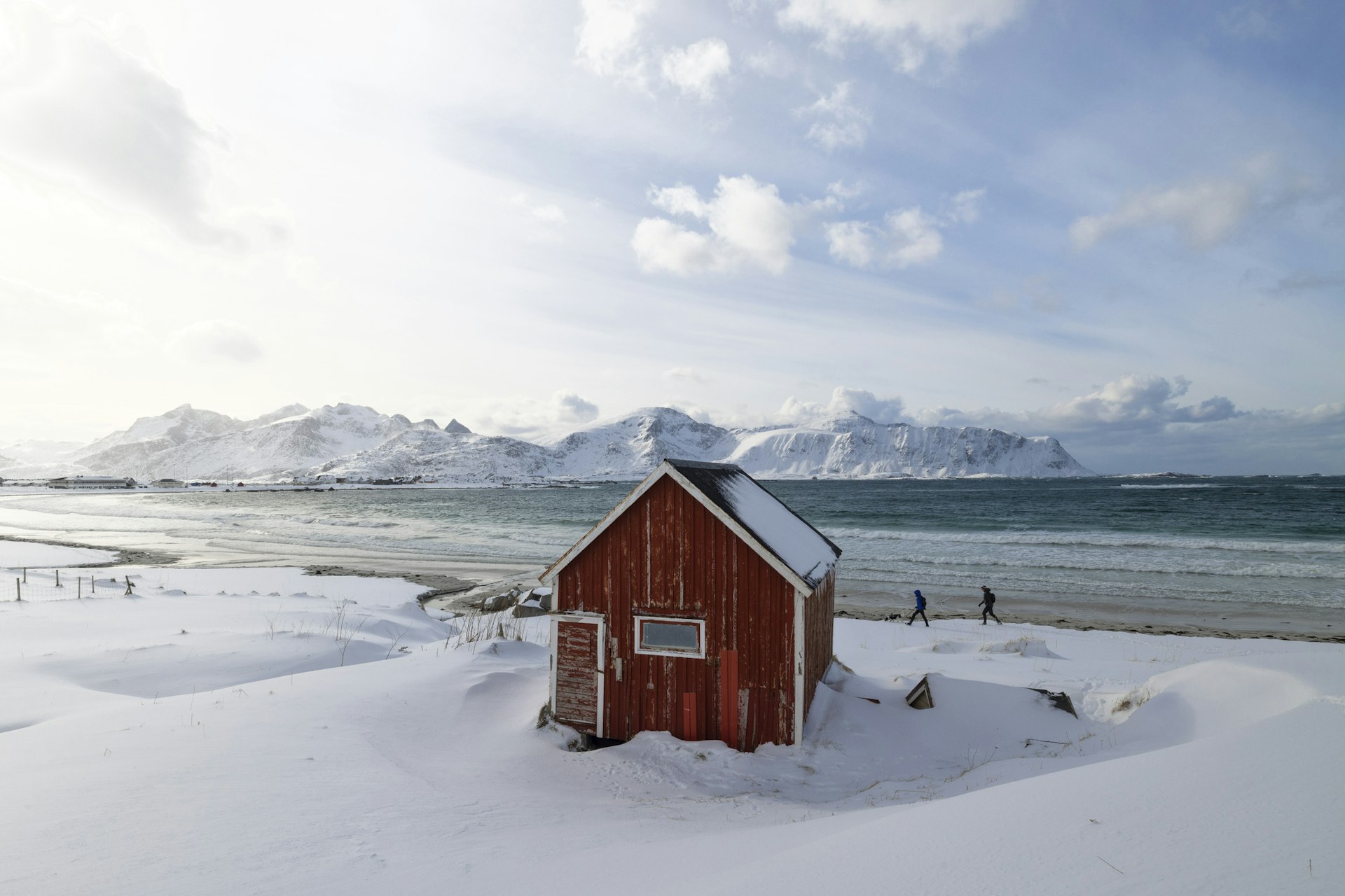the red  Rorbuer hut at the famous beach of Rambergstranda, Lofoten island, Norway but covered in snow