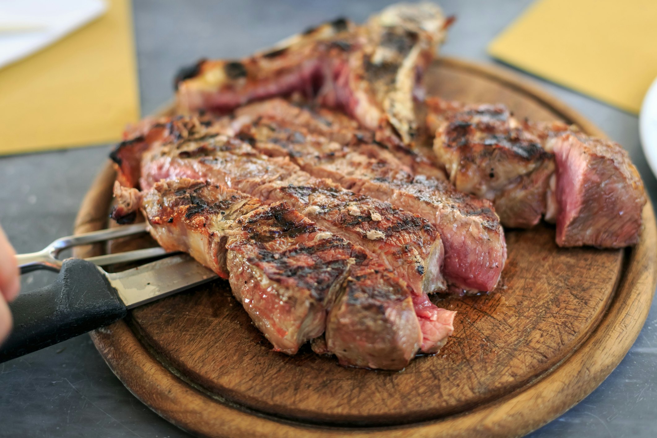 A large cooked steak for sharing on a wooden board