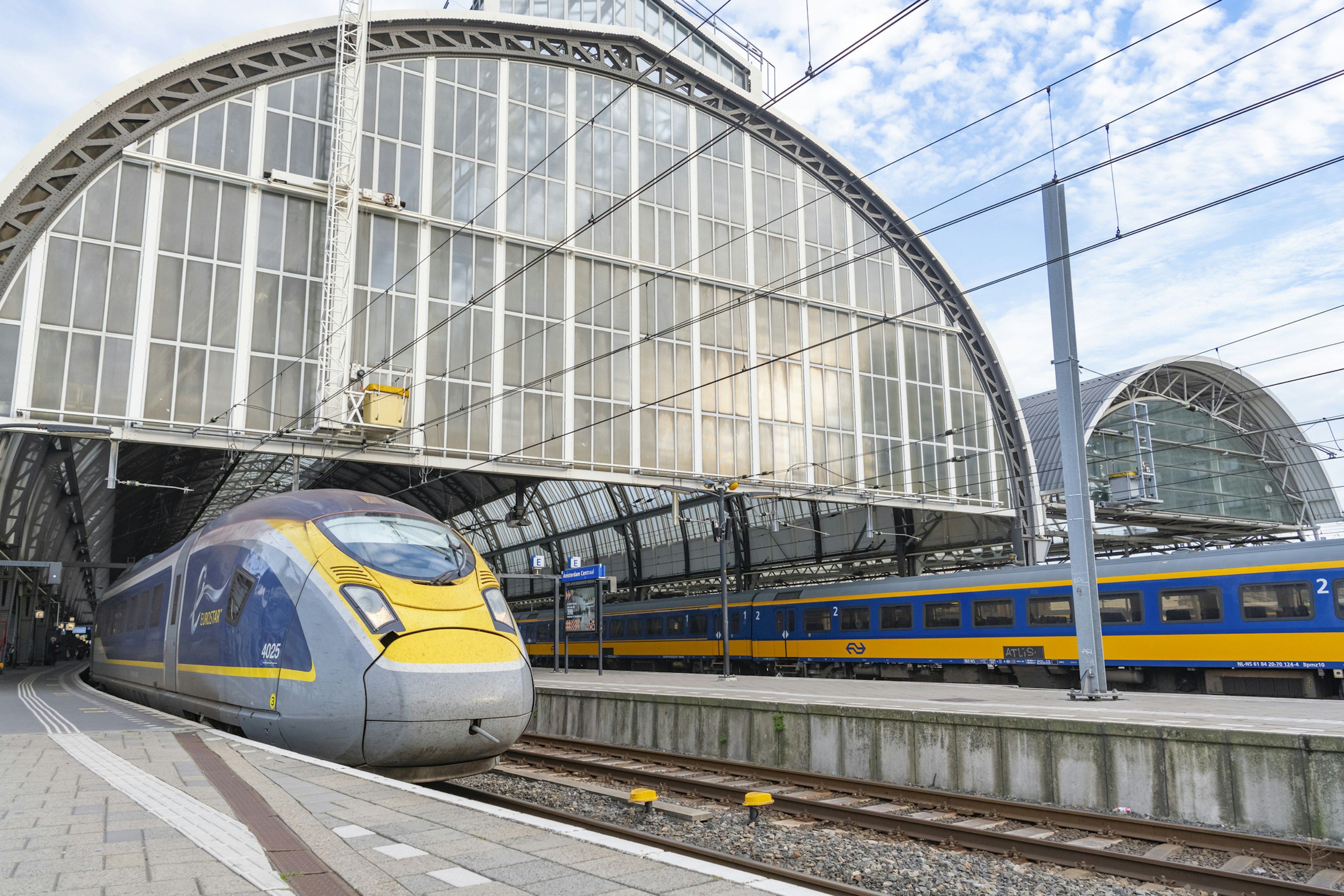 A Eurostar high-speed train leaving Amsterdam Centraal Station for London St Pancras station on a summer's day.