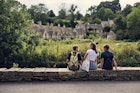 Three teenage kids enjoying summer vacations in Cotswolds, Gloucestershire, United Kingdom. ..They are sitting by the river and looking at the famous row of houses in Bibury...Shot with Canon R5
1667990110