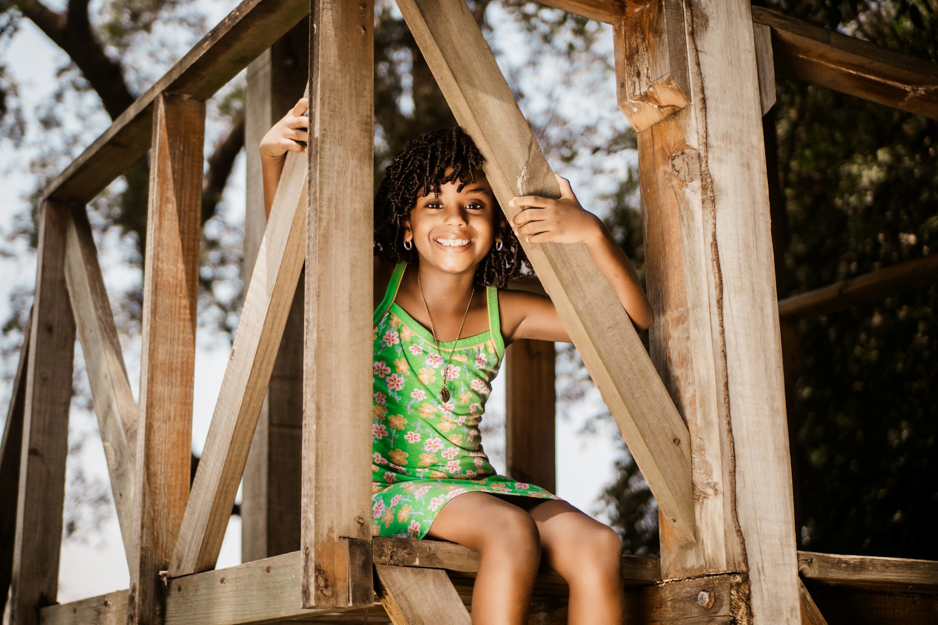 A smiling girl on a climbing frame in a park in Honduras
