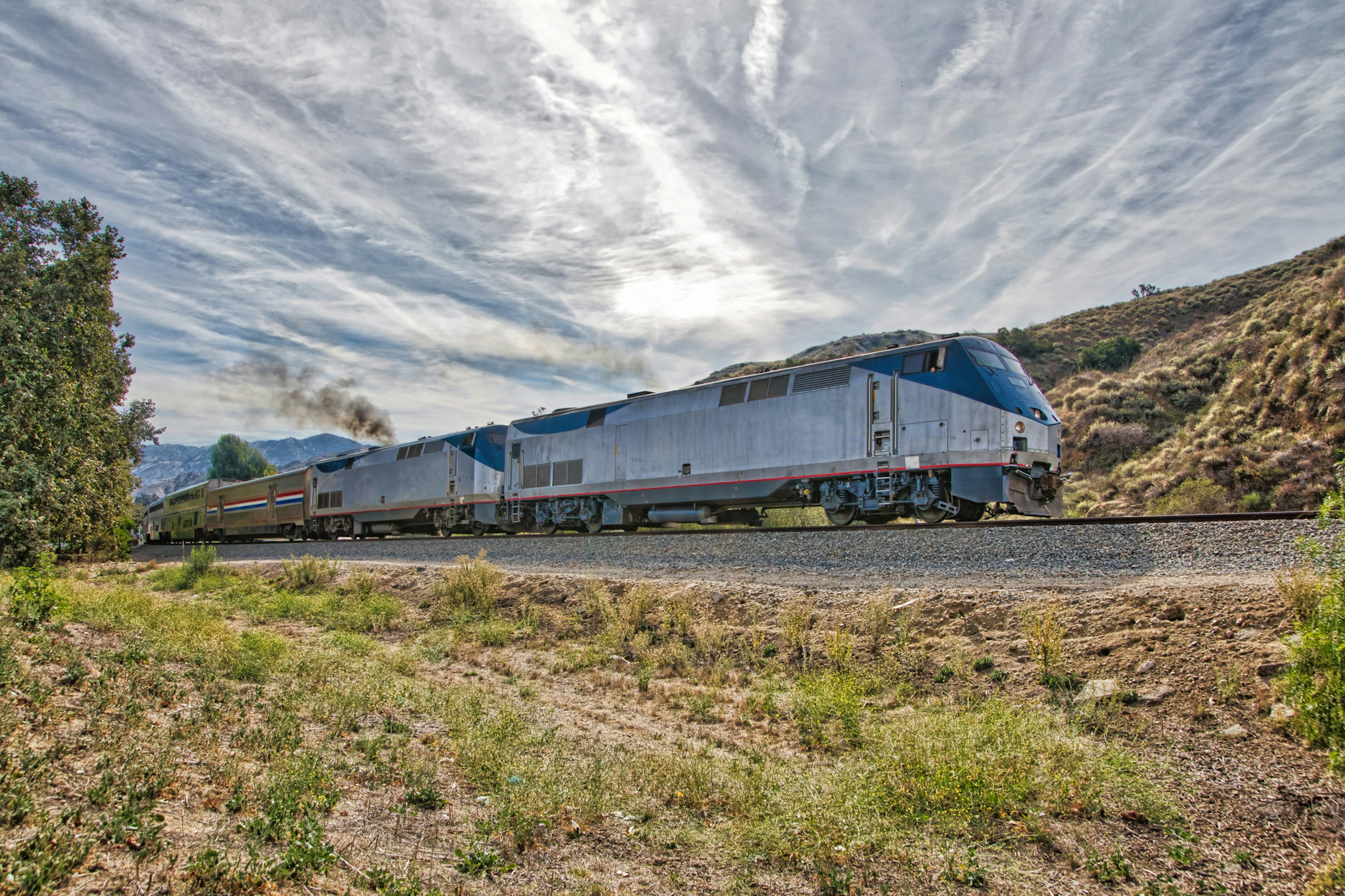 The Amtrak Coast Starlight Train passes along a track through hilly terrain en route to Los Angeles